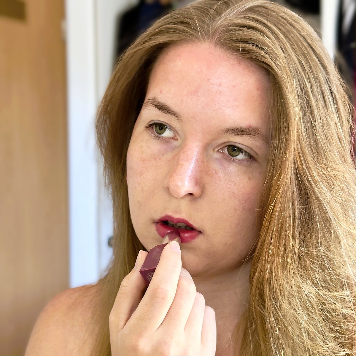Carolin trägt Lippenstift auf